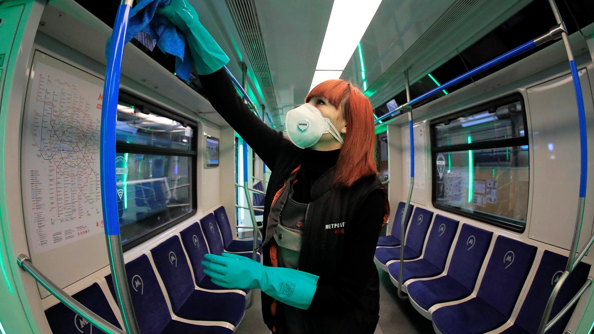 An employee wearing a protective face mask cleans and disinfects a subway train in Moscow