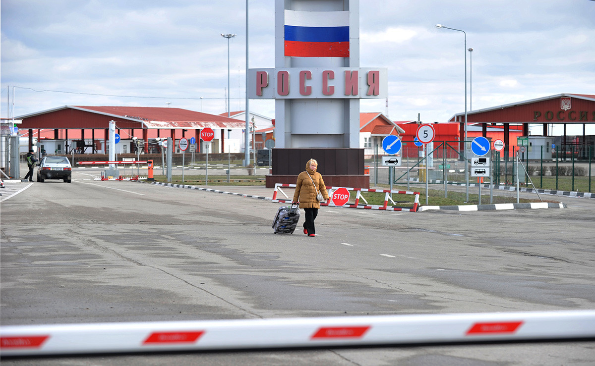A woman walks at the Goptivka checkpoint, near Kharkiv on the Ukrainian-Russian border