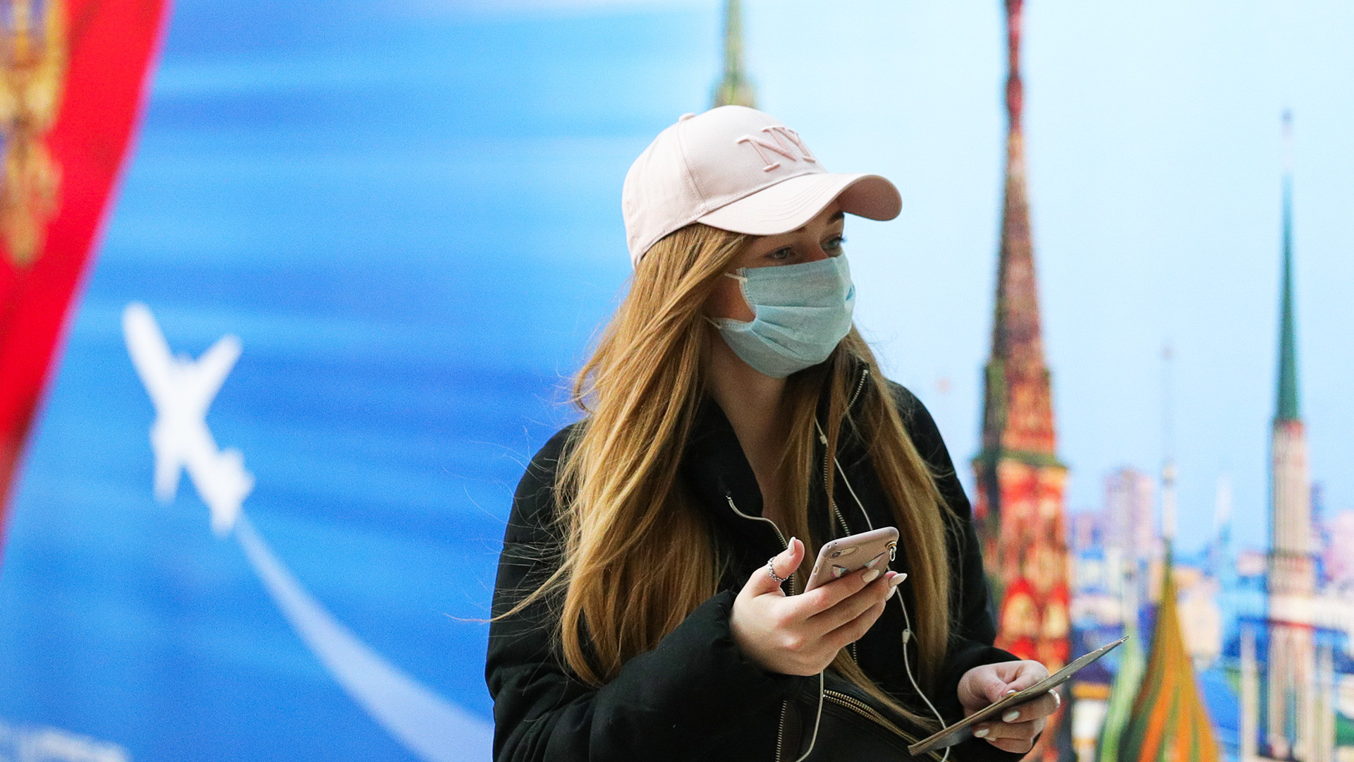 Seorang perempuan dengan masker di Bandara Internasional Sheremetyevo, Moskow.