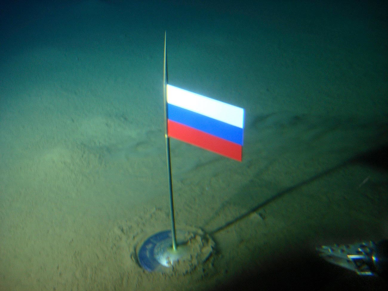 Застава Русије са капсулом од титанијума на дну океана испод Северног пола, неколико секунди након што је 2. августа 2007. године постављена помоћу батискафа Мир-1.