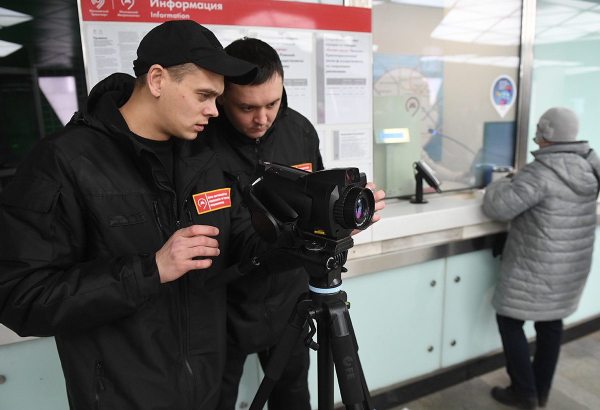 Сотрудники метрополитена проверяют у пассажиров московского метро температуру с помощью тепловизора.