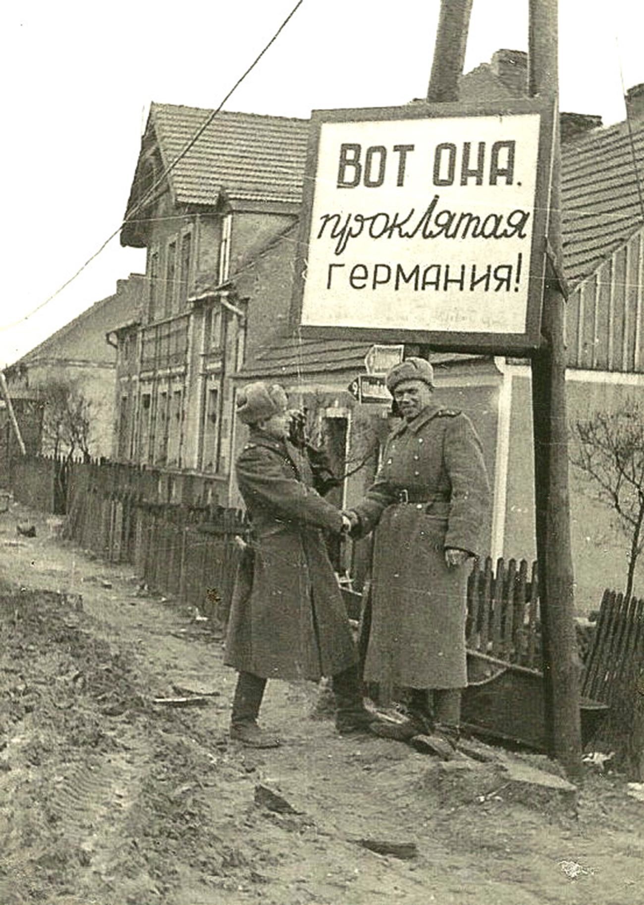 The sign reads: “There she is, cursed Germany!” War videographers Ilya Arons (left) and Boris Dementyev at the former border between Poland and Germany during the filming of ‘Battles in Pomerania’ in April 1945