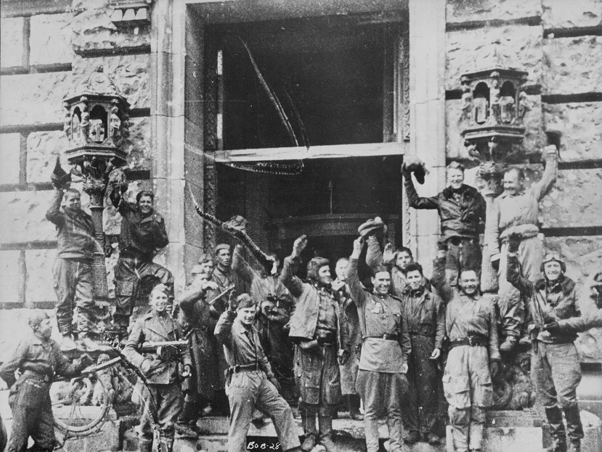 Војници Црвене армије славе победу над нацистичком Немачком испред зграде Рајхстага после Битке за Берлин у Другом светском рату. Немачка 1945.