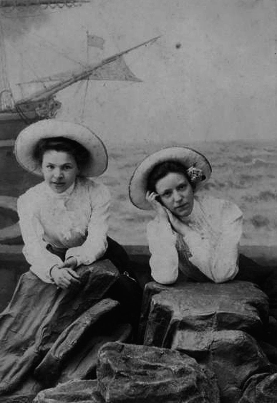 Two women posing in hats