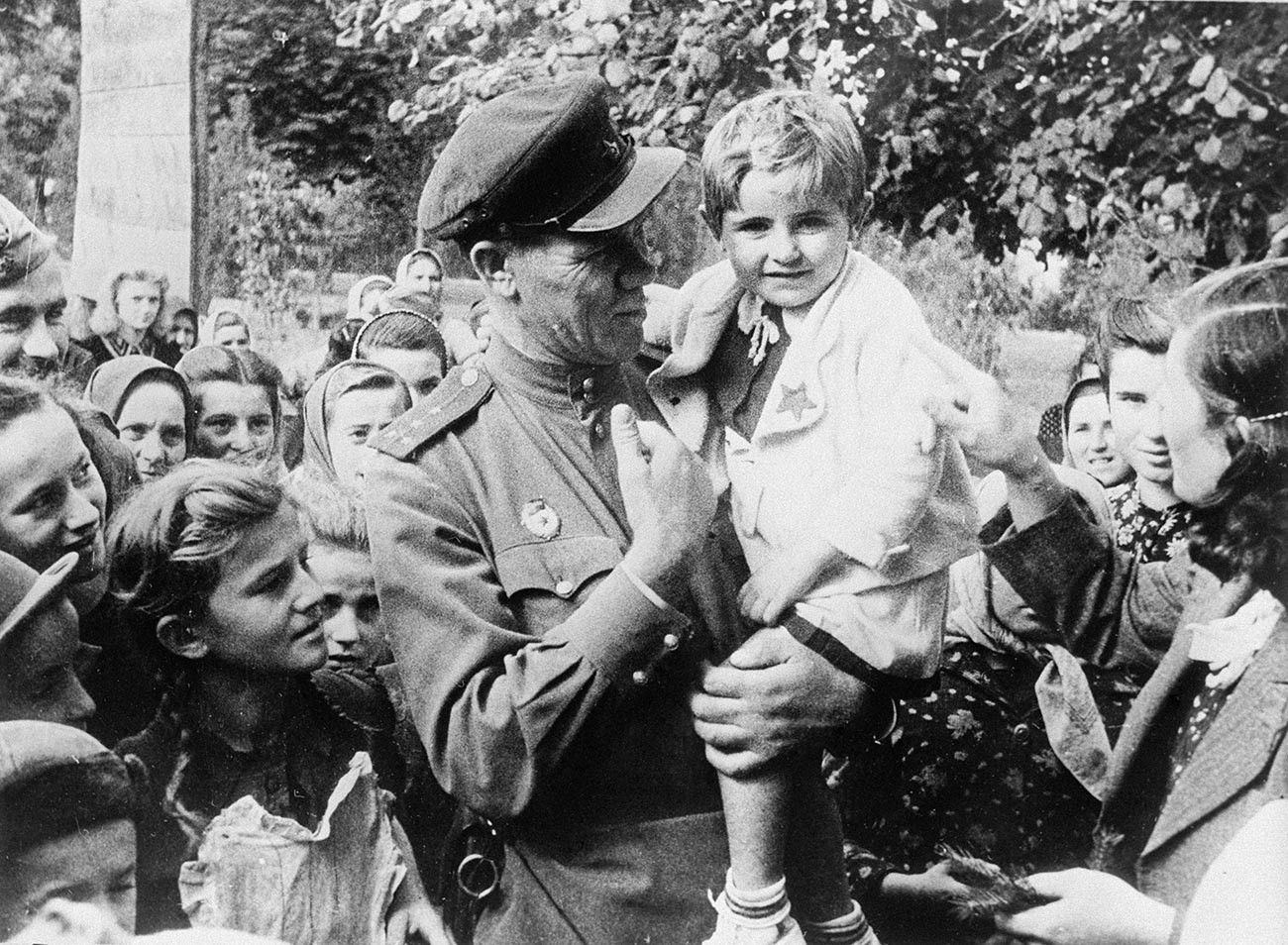 解放されたユーゴスラビアのオモリツァ村で子供を抱く赤軍親衛隊のセルゲイ・イワノフ大尉。1944年10月。