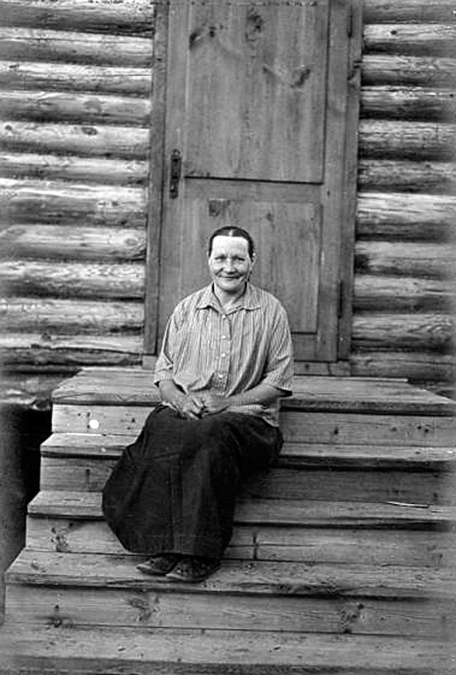 木造の玄関に座る女性のポートレート