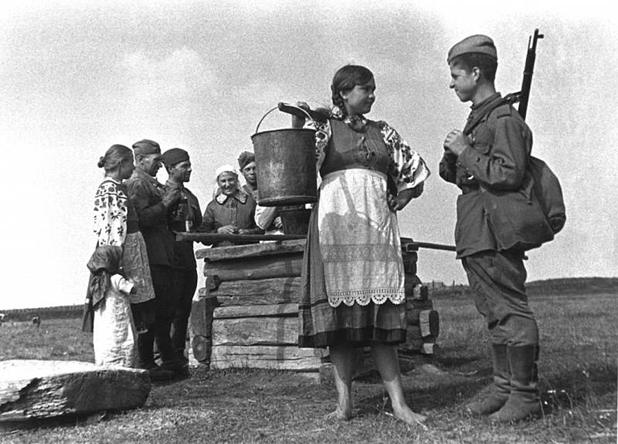 Ein junges Mädchen und ein Soldat an einem Brunnen