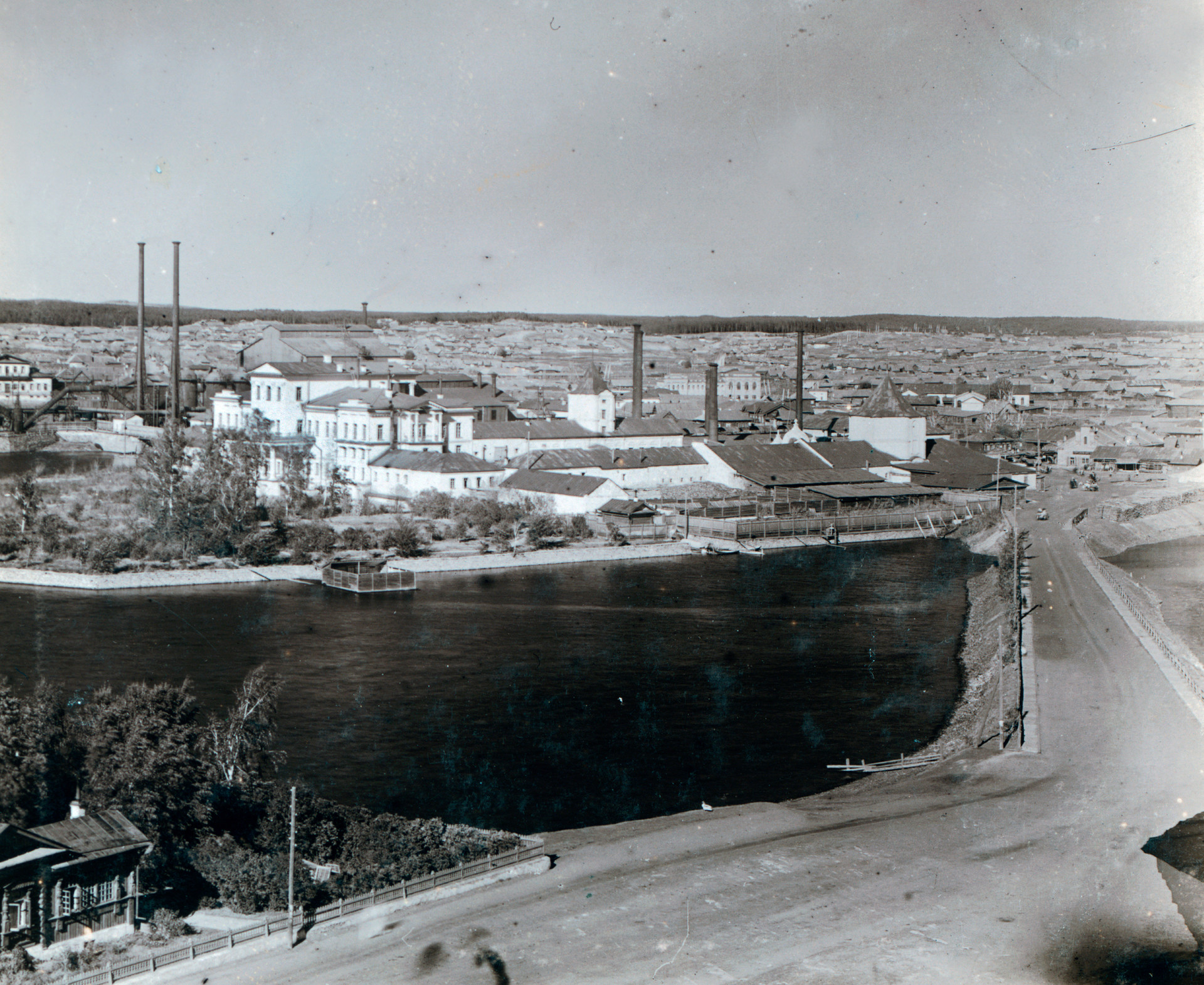 View of main Kyshtym factory with White House on former Demidov estate. Foreground: Town Pond (Kyshtym River). Right: 18th-century tower built by Nikita Demidov. 1909.