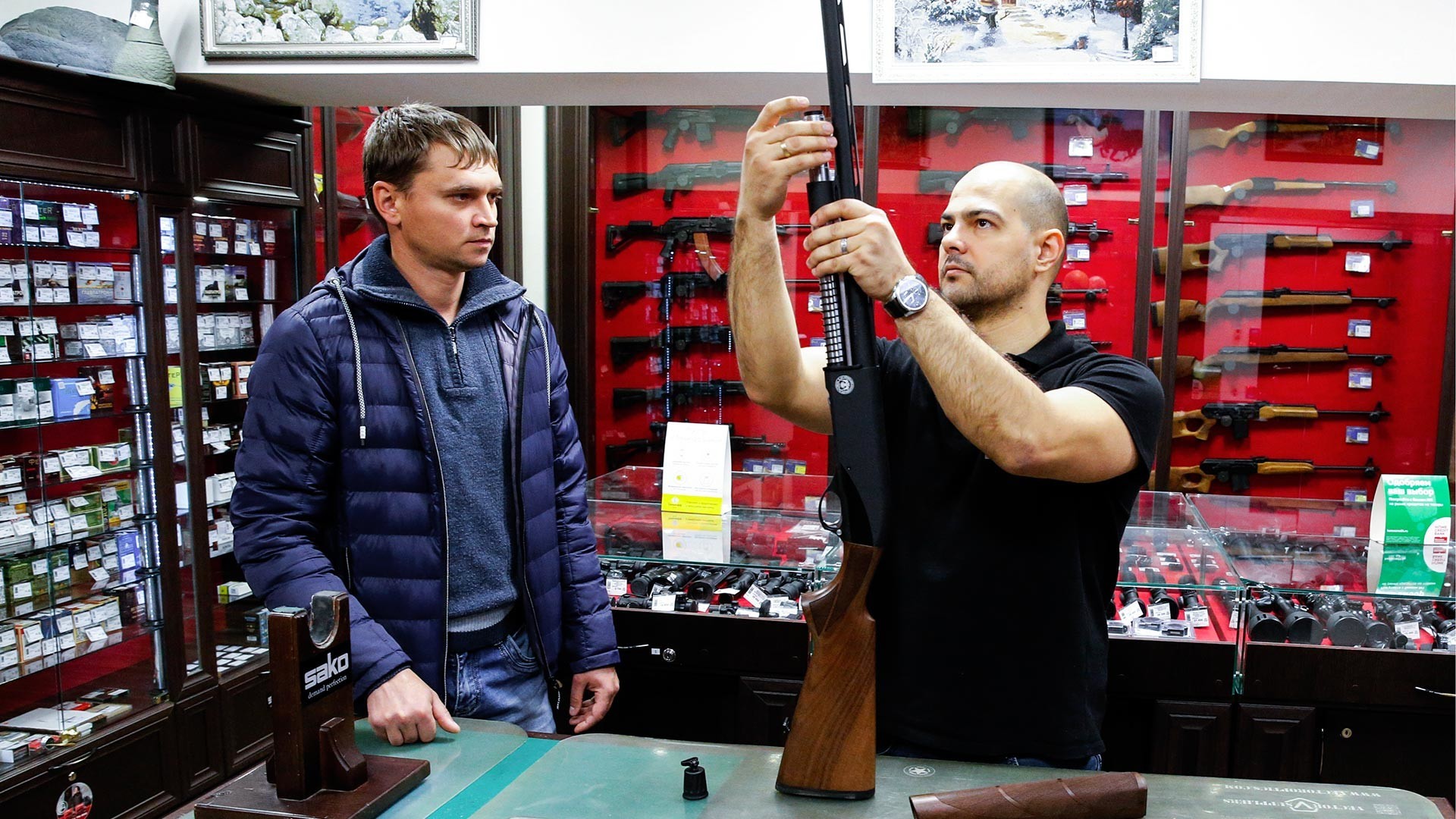 Stranka si ogleduje puške v prodajalni orožja v Čeljabinsku.
