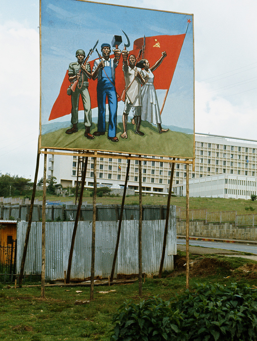 Пропаганден плакат показва няколко етиопци, които държат комунистически символи пред съветското знаме, в Адис Абеба, столицата на Етиопия, 1977 година