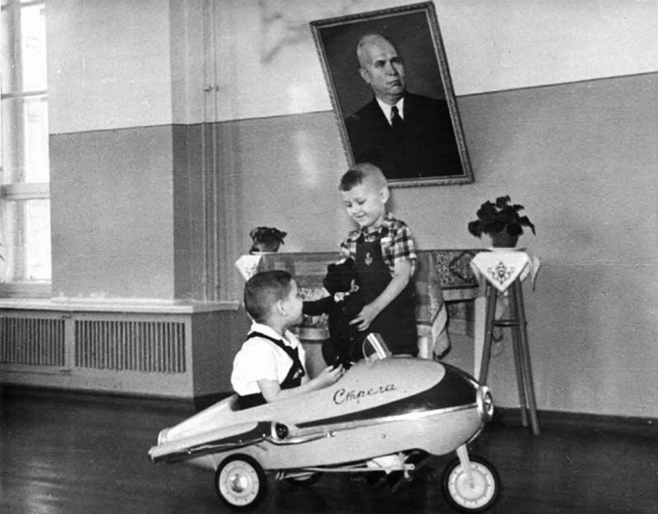 Niños jugando con un coche de pedales Strelá, 1962.