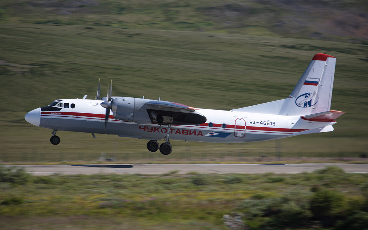 An-24 RV air liner belonging to Chukotavia airlines seen above the take-off runway of an airport