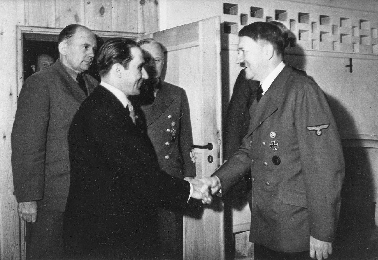 Адолф Хитлер са замеником премијера Михаја Антонескуа (лево) у фиреровом седишту „Вучја јазбина“ код Винице (Украјина). У позадини са леве стране: доктор Паул Ото Шмит, главни преводилац.