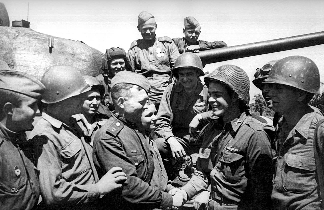 В центре - командир танка младший лейтенант Георгий Ловчиков здоровается с лейтенантом американской армии Жаком Хальтгрейвсом