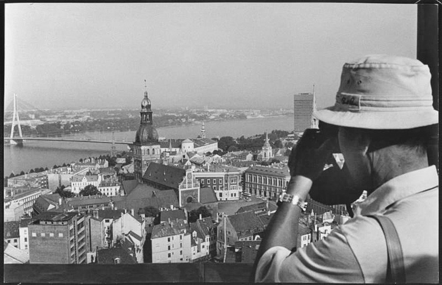 1978 година. Фотографот Виктор Рујкович ја снима панорамата на градот. Кулата на Домската катедрала, зад неа Мостот преку реката Даугава.