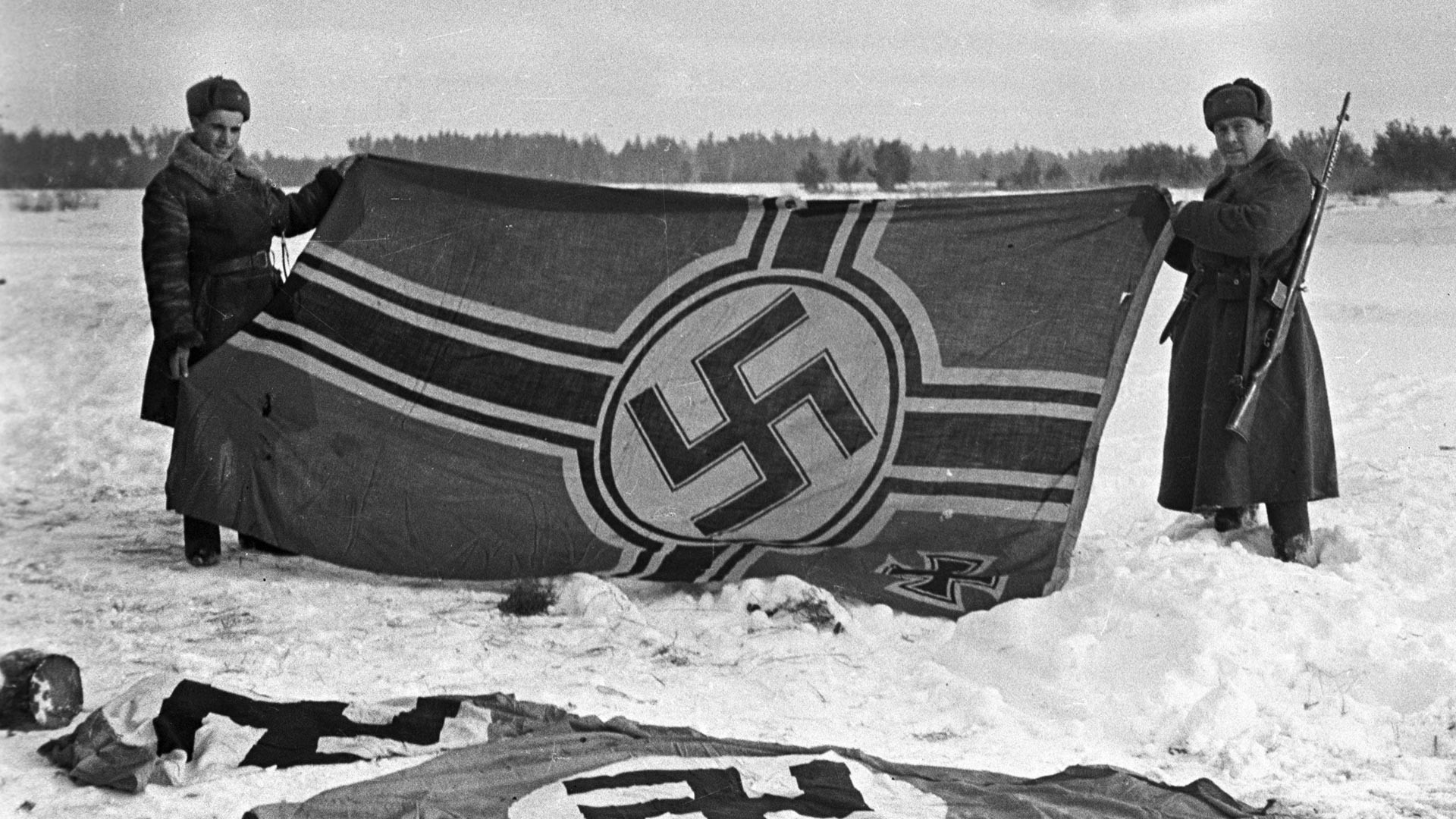 Dua prajurit Soviet menunjukkan bendera Nazi pertama yang direbut dalam pertempuran di dekat Kalinin, 1941.
