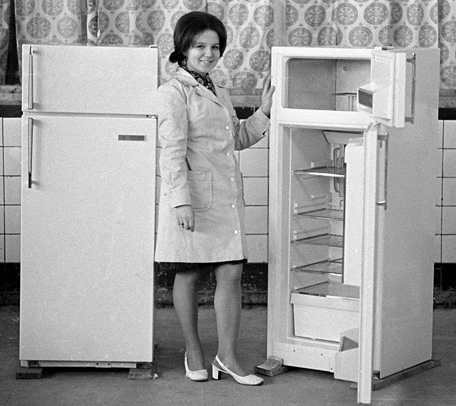 Funcionário da Fábrica de Refrigeradores de Minsk demonstrando a geladeira Minsk-7, 1973. Metade de todas as casas soviéticas tinha uma dessas