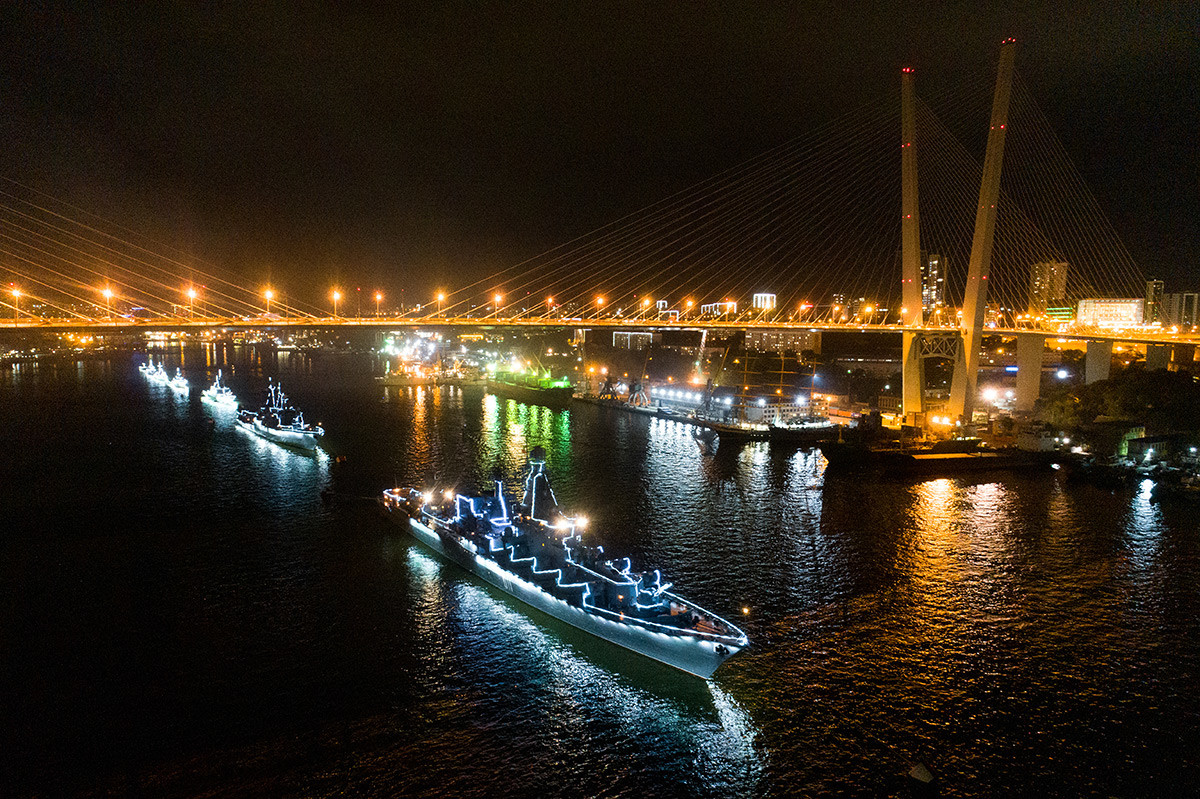 Des navires illuminés de la Flotte du Pacifique paradent dans la baie de la Corne d'Or, à Vladivostok.