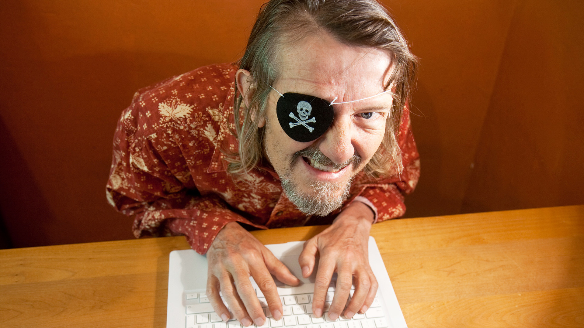 An unscrupulous pirate downloads content from a laptop computer