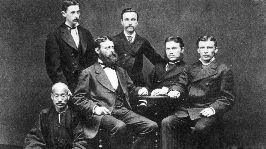 Управлението на компанията "Кунст и Алберс" на последната среща във Владивосток през 1880 г. На масата са (отляво надясно): Густав Алберс, Густав Кунст и Адолф Датан, зад тях стоят датчанинът Антон Нилсен (вляво) и М. М. Дмитриев (вдясно), По-долу е Чи Мо Чен, който е шеф на китайските работници
