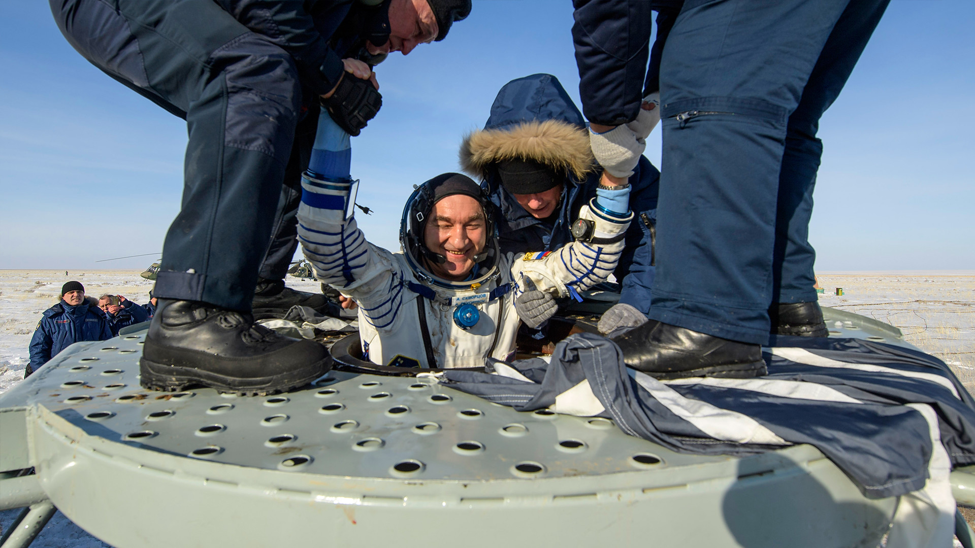 Ruskom kozmonautu Aleksandru Skvorcovu pomažu pri izlasku iz svemirske letjelice Sojuz MS-13, samo nekoliko minuta nakon slijetanja u kazahstansku stepu u blizini grada Džezkazgana. 6. veljače 2020. godine.


