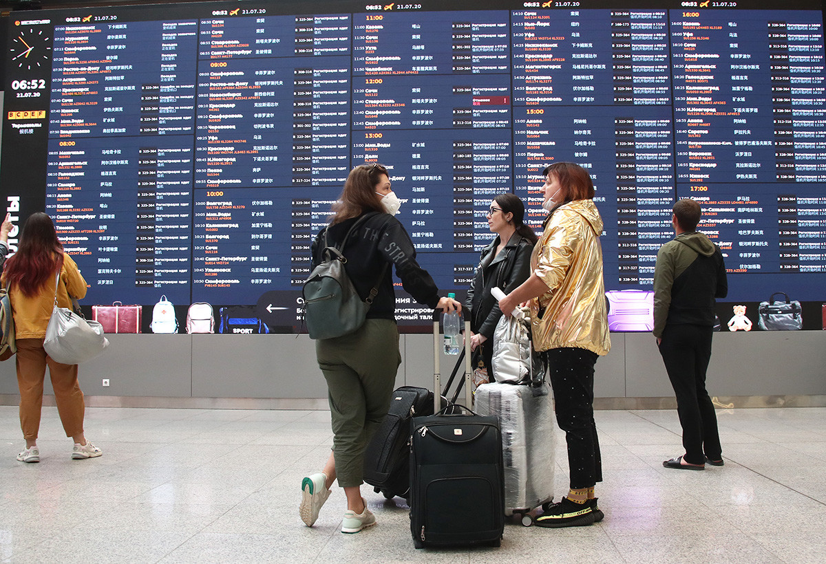 People near an information board at Terminal B at the Sheremetyevo International Airport near Moscow during the pandemic of the novel coronavirus disease (COVID-19), july 21,2020