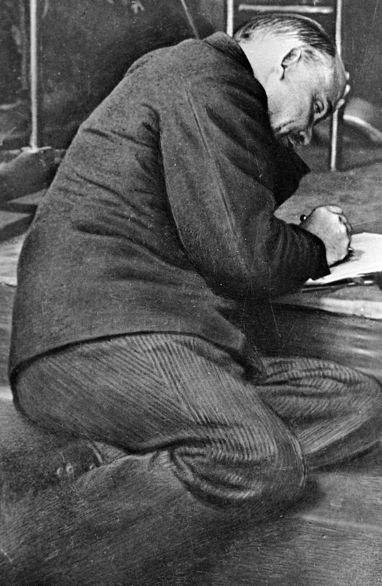 Ленин делает записи на ступеньках трибуны во время заседания III-го конгресса Коминтерна в бывшем Андреевском зале Кремля