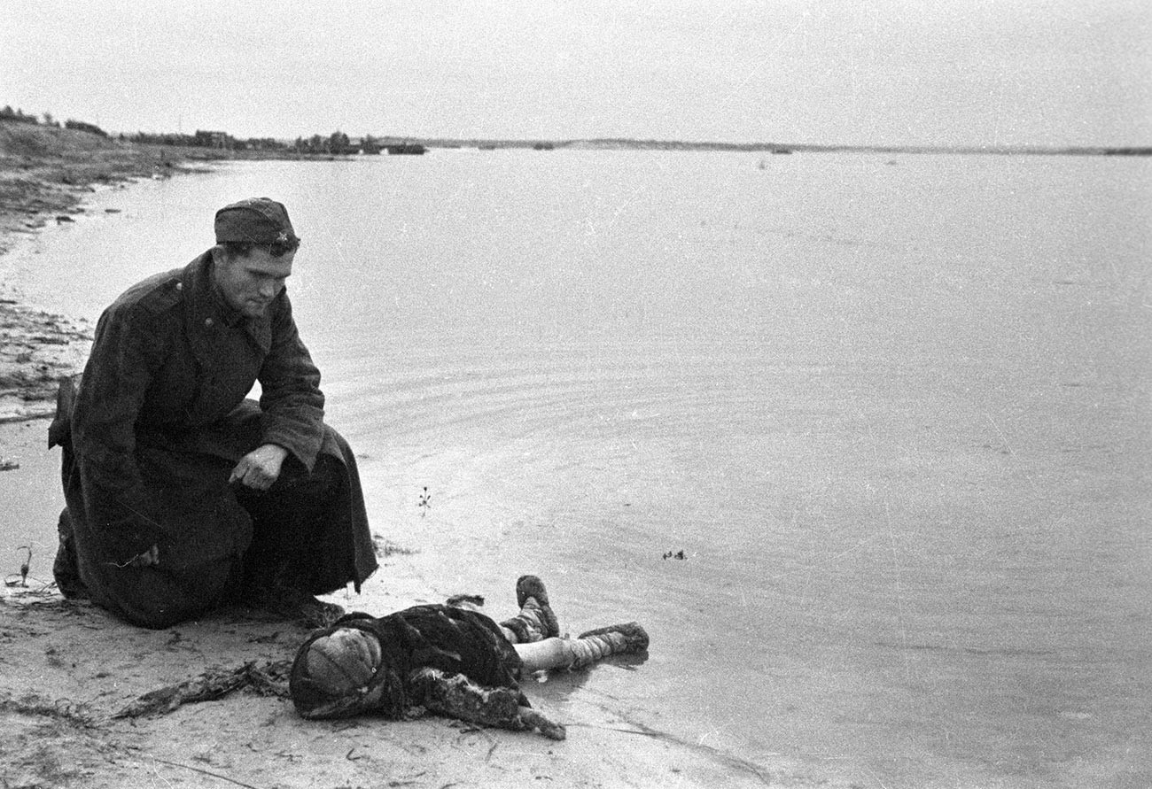 Un soldat soviétique au bord du Dniepr est en deuil d'un enfant assassiné par les nazis
