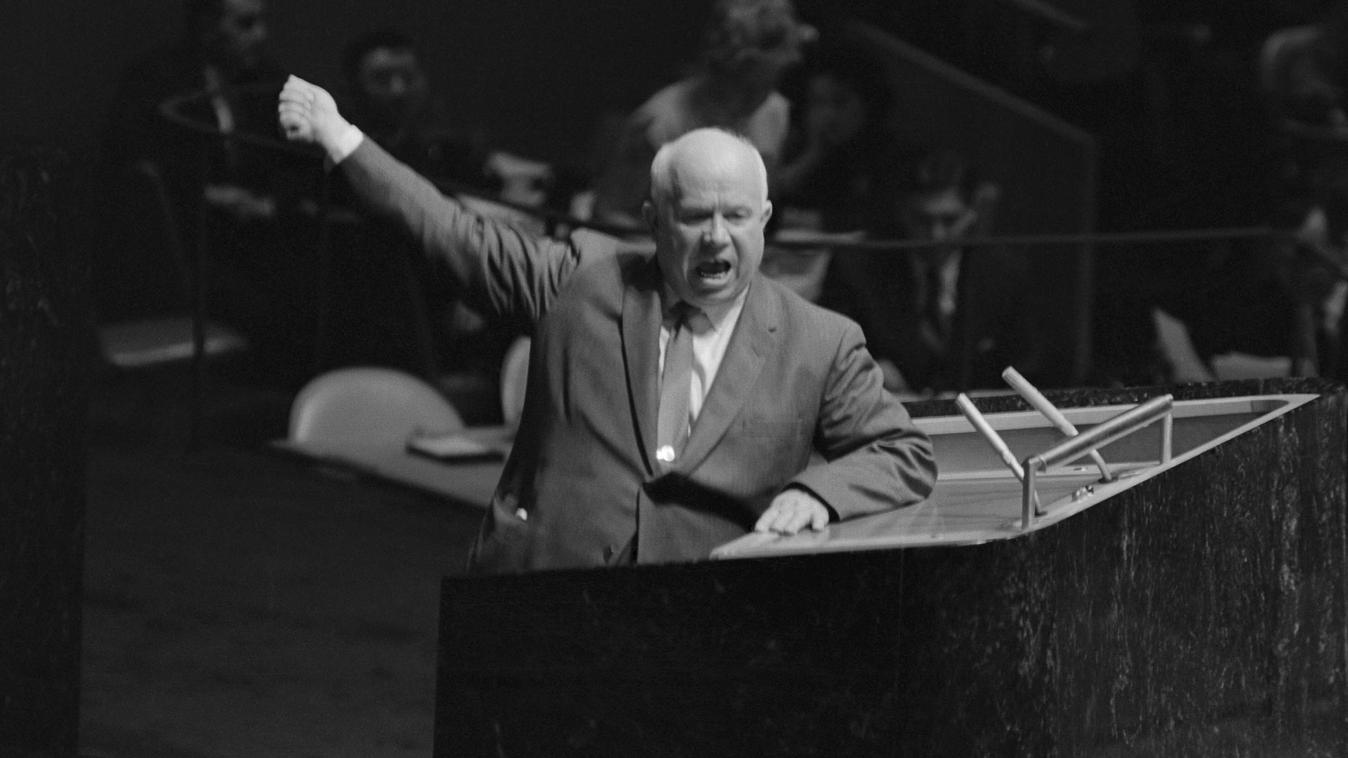 Совјетски лидер Никита Хрушчов гестикулира и виче за говорницом Генералне скупштине УН, тражећи од председавајућег Фредерика Боланда да одузме реч Лоренцу Сумулонгу са Филипина који је предлагао да СССР изврши деколонизацију Источне Европе. Генерална скупштина УН, 12. октобар 1960.
