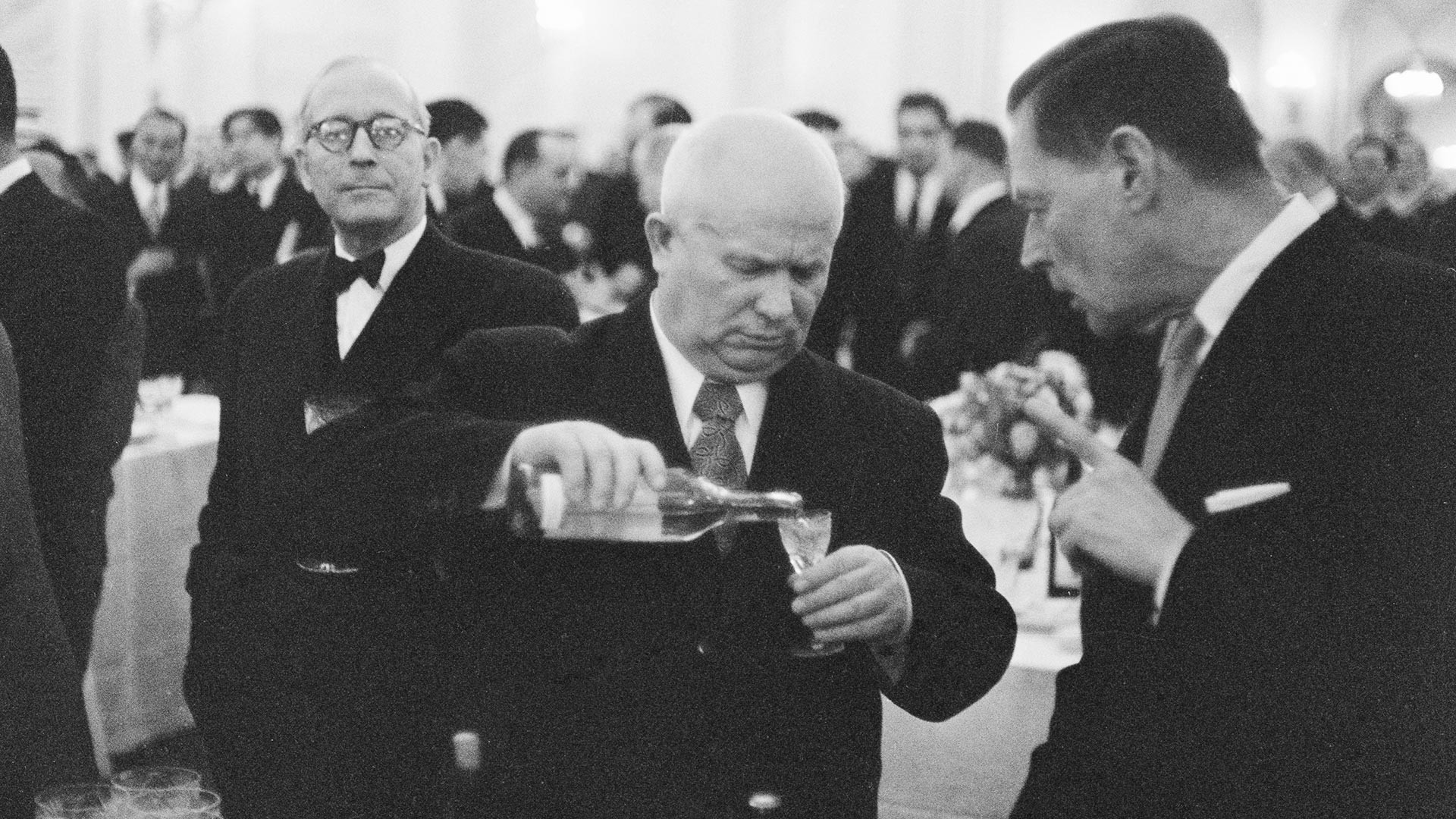 Nikita Khrushchev minum dengan Charles E. Bohlen, Duta Besar AS untuk Uni Soviet, pada acara resmi, 1955.