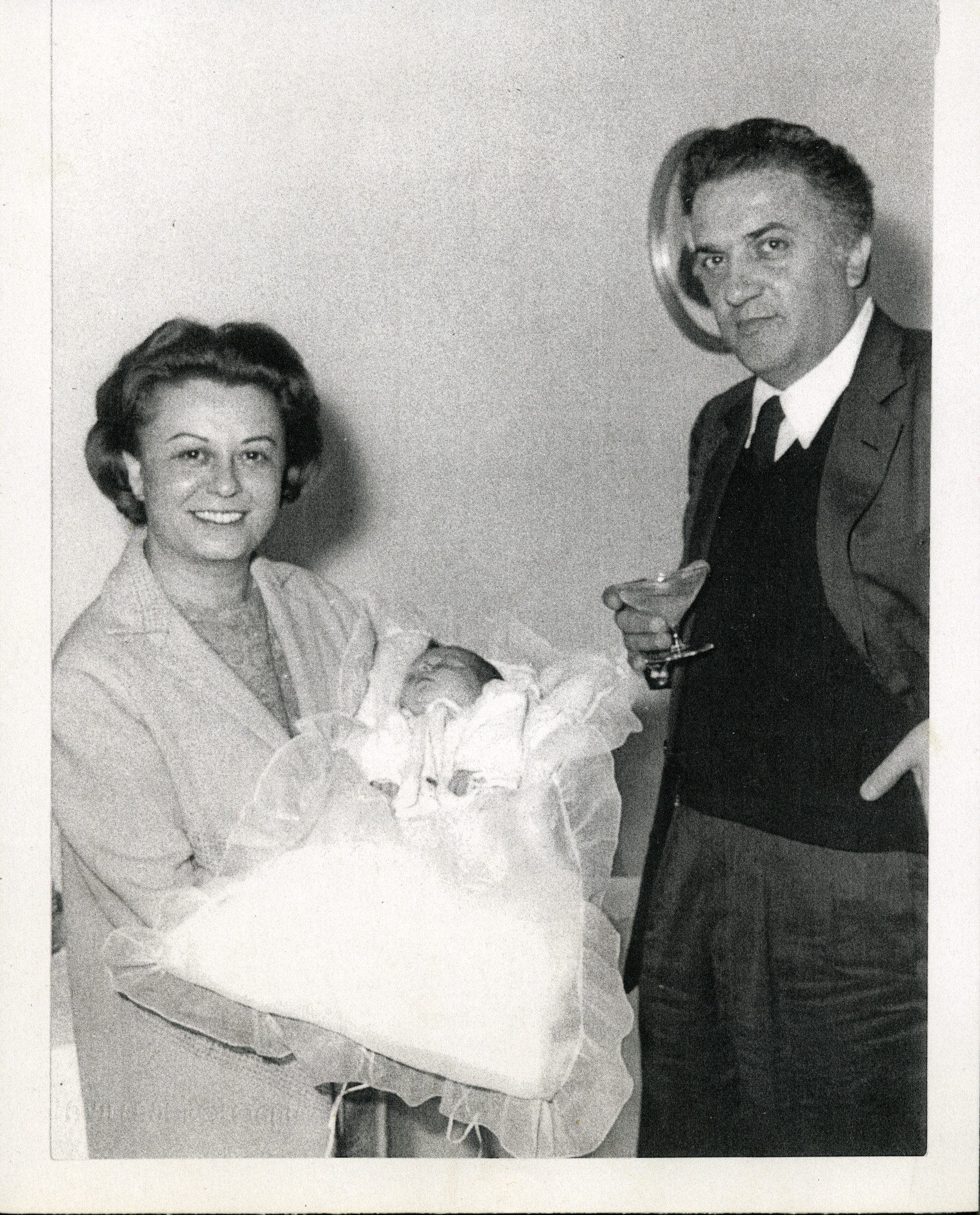 Federico Fellini con Giulietta Masina, che tiene in braccio la nipote del regista, Francesca, nel giorno del suo Battesimo