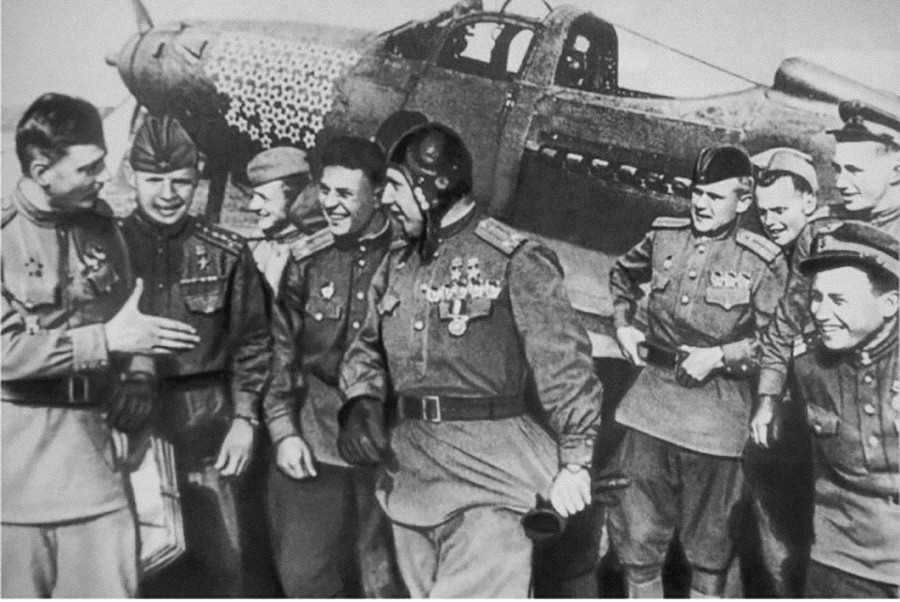 アレクサンドル・ポクルィシキン（ヘルメットをかぶる方）を祝う同僚たち、第16戦闘機航空連隊、1944年の夏。