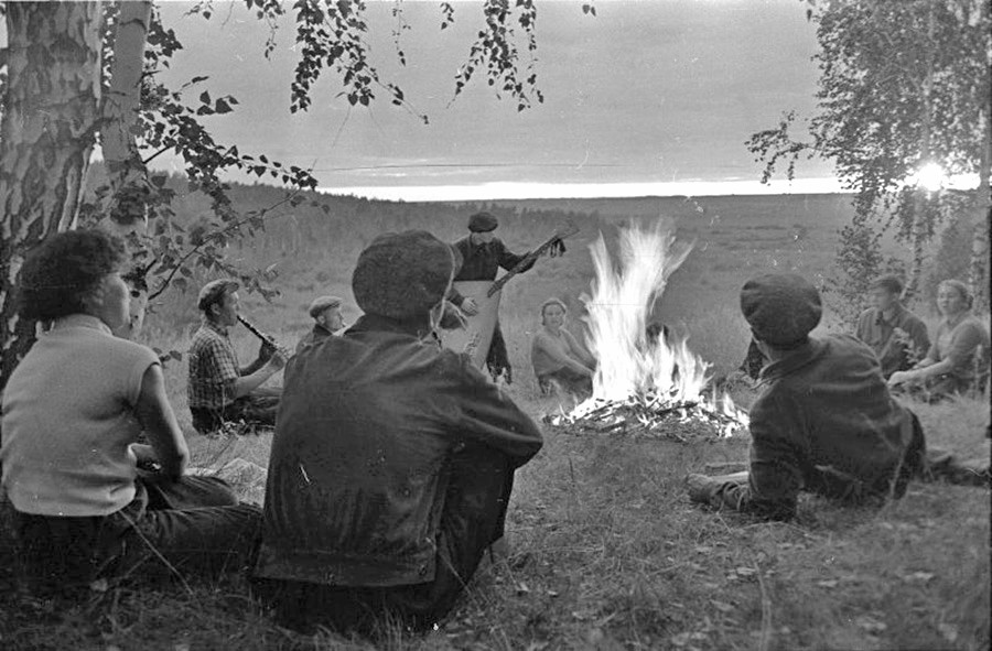 Para mahasiswa bermain musik di dekat api unggun. Altai, 1957–1963.