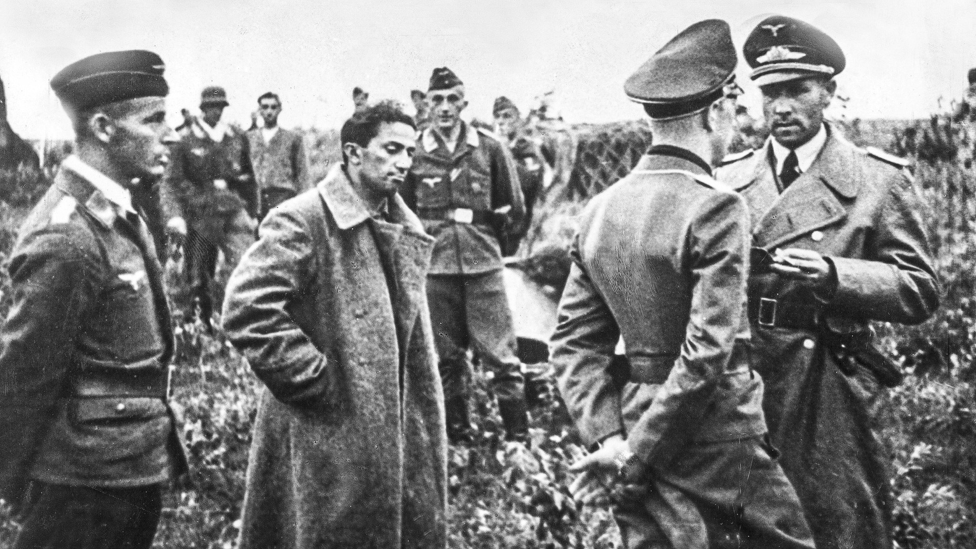 Iakov Djougachvili entouré d'officiers allemands après sa capture. En attente d'un transfert aérien vers l'arrière pour être interrogé.