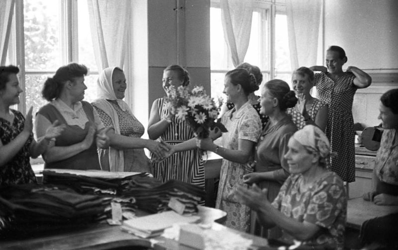 Donne donano fiori per il compleanno di una collega nella fabbrica di abbigliamento “40 anni del Komsomol” a Tiraspol, RSS Moldava, nel 1964
