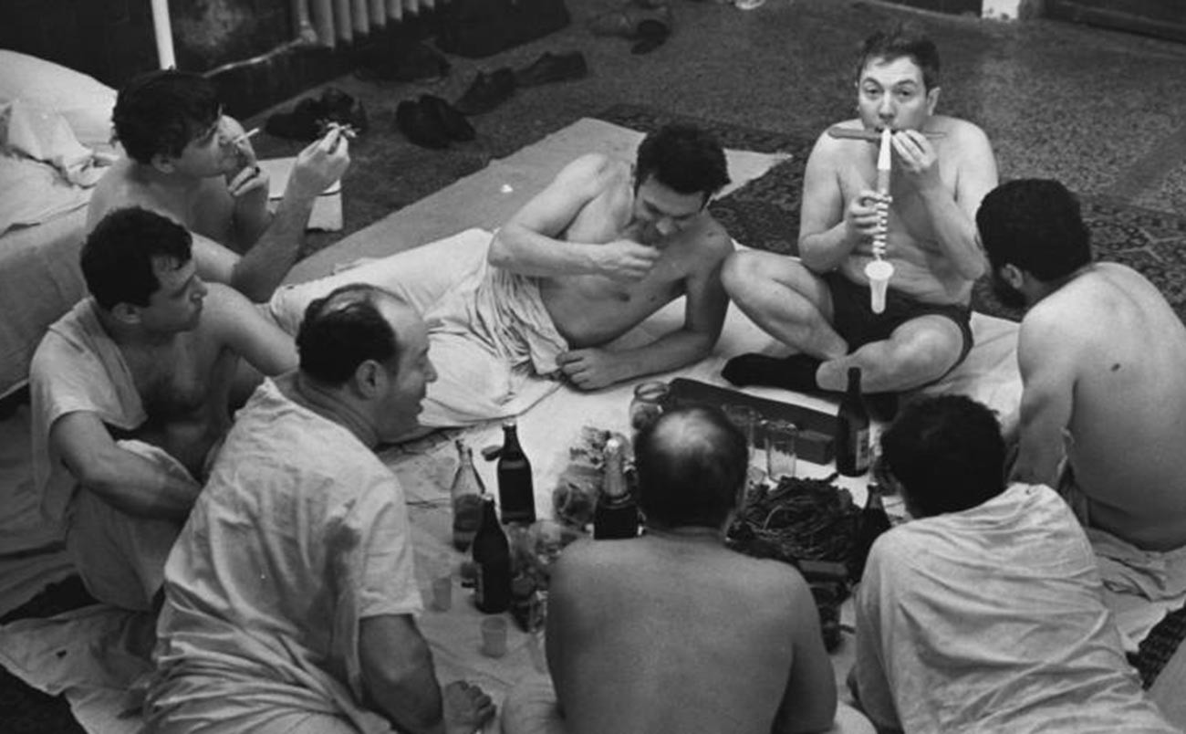 Uomini bevono birra e mangiano pesce essiccato al compleanno di Anatolij Eliseev
