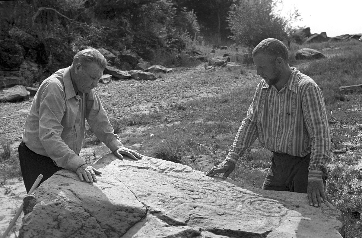 L'académicien Alexeï Okladnikov (à gauche) et le candidat en sciences historiques Alexandre Konopatski étudiant les pétroglyphes