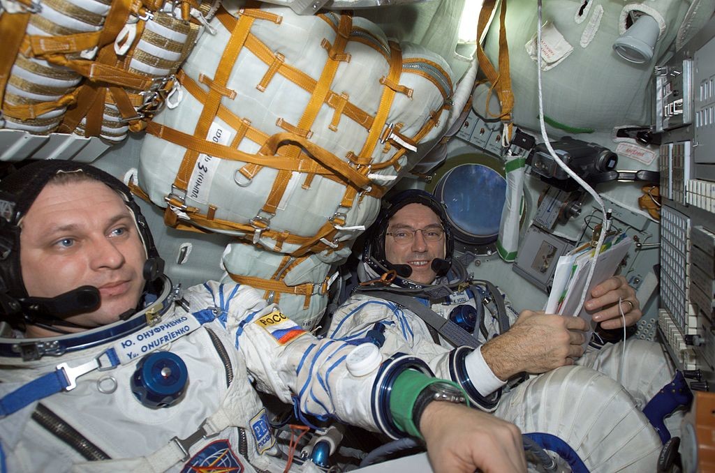 Космонавтът Юрий Иванович Онуфриенко (вляво) и астронавтът Карл Е. Валц, командирът на съответно четвъртата експедиция и борден инженер, облечени в руски скафандри 