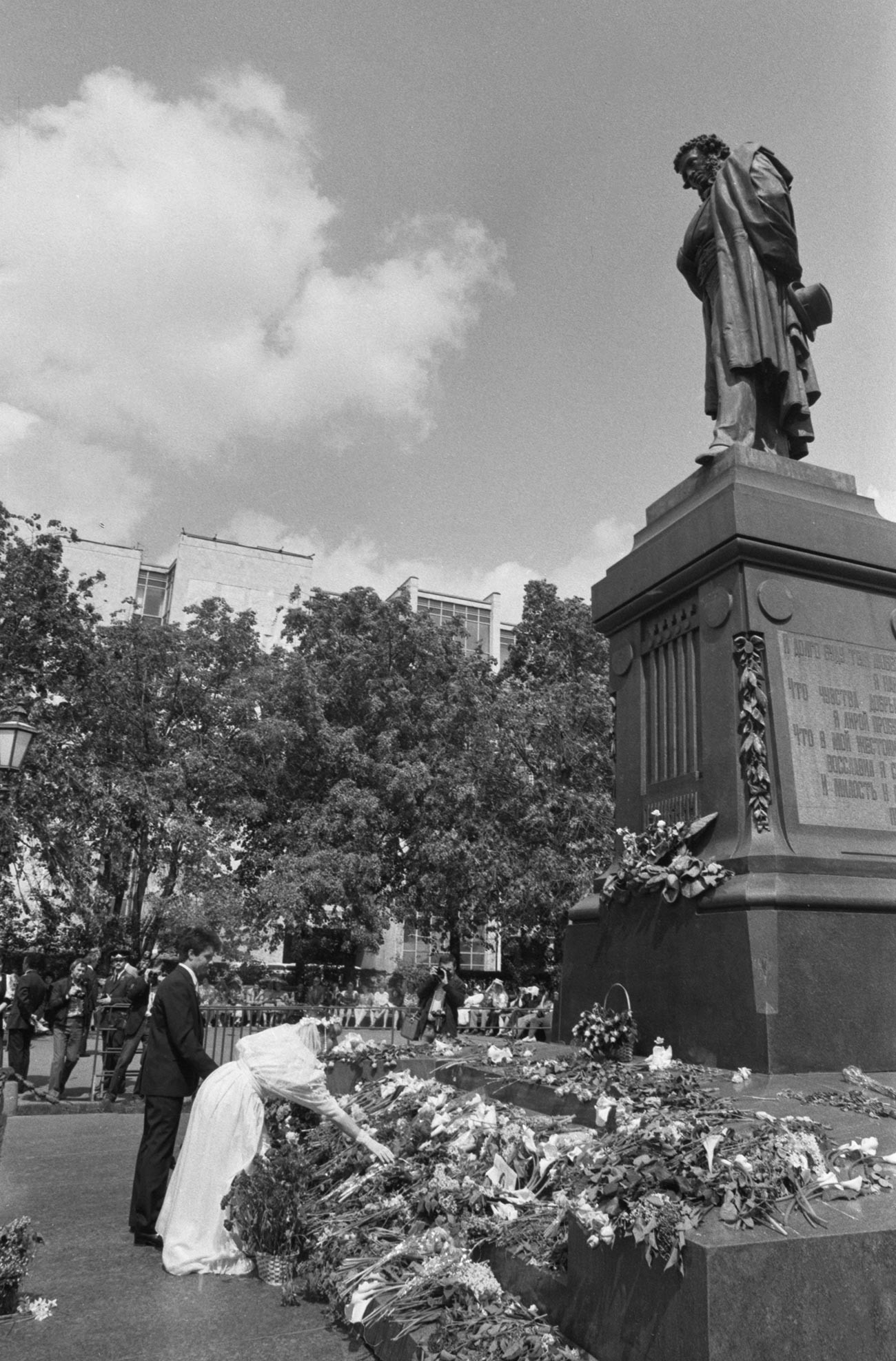 Jeunes mariés déposant des fleurs au pied de la statue de Pouchkine, à Moscou