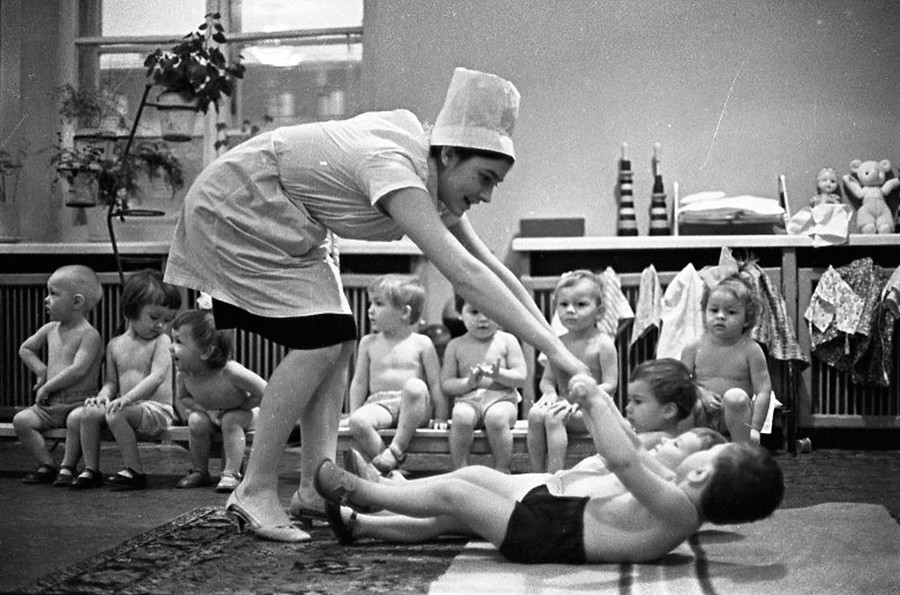 Nella scuola materna si insegnava ai bambini a fare sport regolarmente. Nella foto, una dottoressa mostra ai bambini come fare ginnastica, 1965