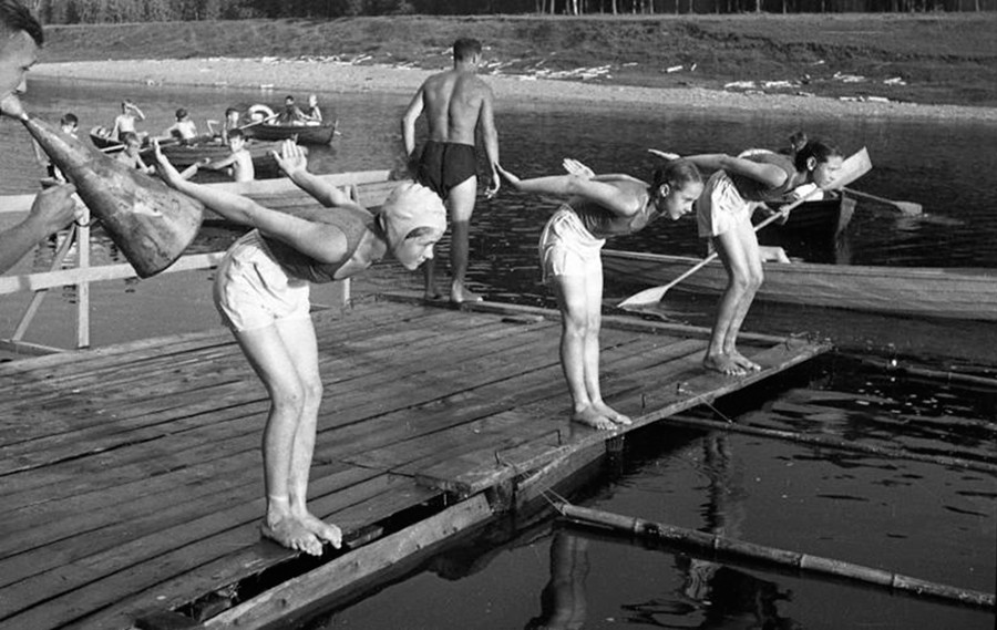 Drei Schulkinder, die sich auf einen Schwimmwettbewerb vorbereiten, 1946