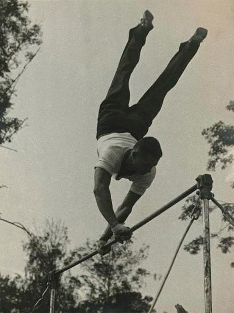 Un homme réalisant une figure sur barres, 1935