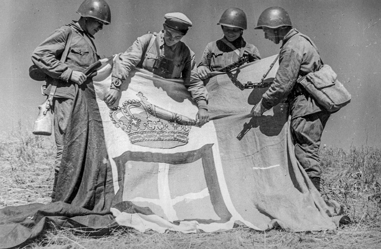 Soviet troops with the captured standard of an Italian regiment.