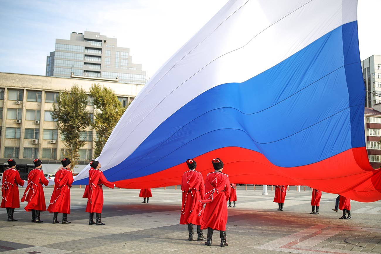 Торжественная церемония поднятия Государственного флага Российской Федерации казаками почётного караула Кубанского казачьего войска в День народного единства на главной городской площади в Краснодаре. 