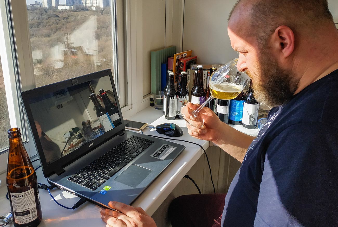 A beer chain consultant tastes some samples at home during a live video conference in Moscow during self-isolation.