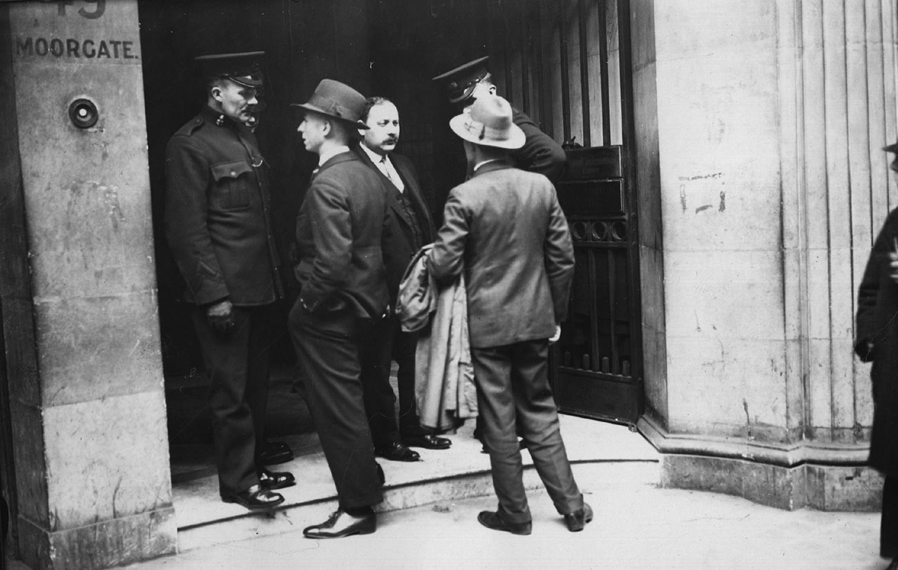 13 май 1927 г.: Полицейски инспектори оглеждат хора извън търговската организация на съветското правителство ARCOS в Мургейт, Лондон, по време на полицейска акция.