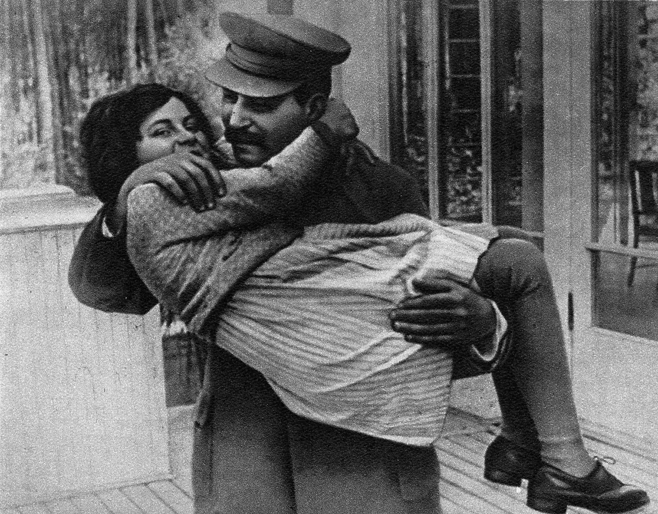 Joseph Stalin menggendong putrinya Svetlana dengan kedua tangannya.