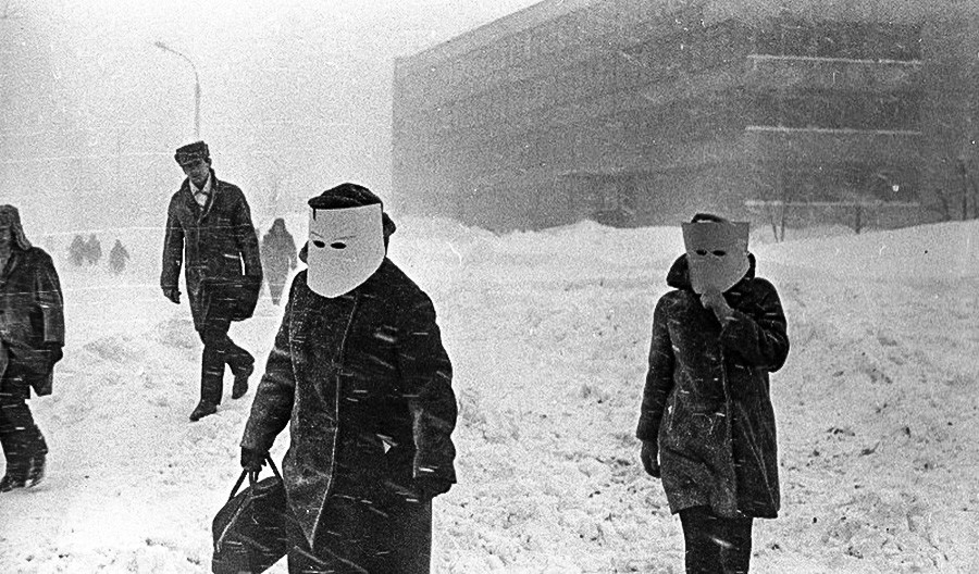 Mujeres tratando de proteger sus rostros de una tormenta de nieve.

