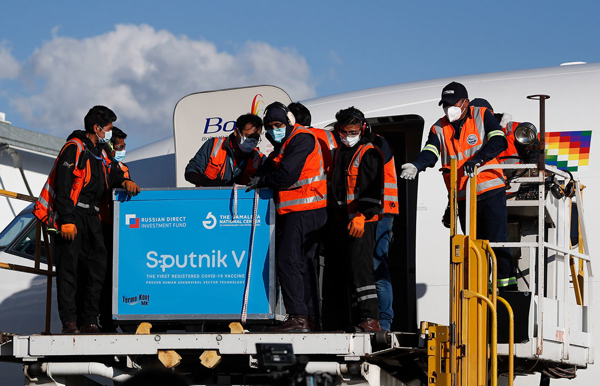 Airport employees unload the first shipment of Russia's Sputnik V COVID-19 vaccine after it arrived at the international airport in El Alto, Bolivia, Jan. 28, 2021.