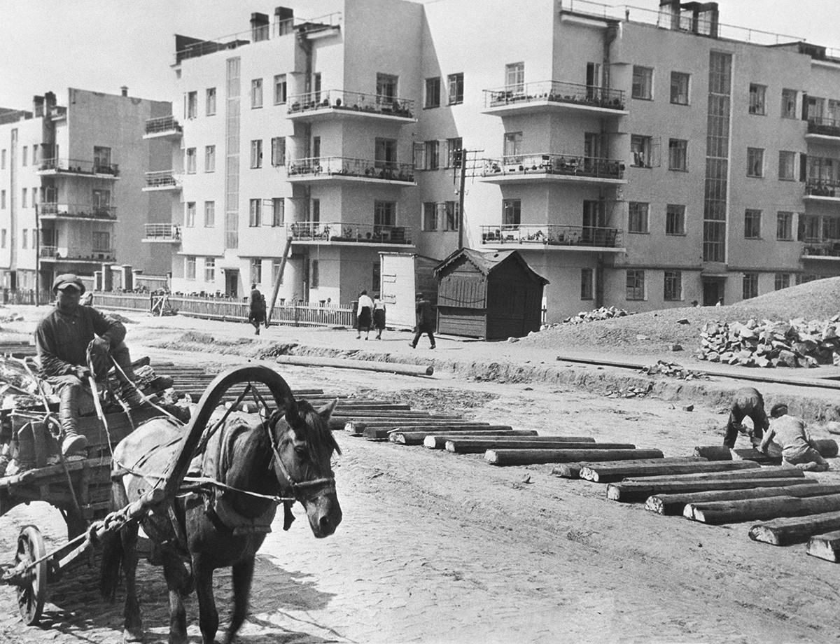 Novosibirsk, 1934 (circa). Operai durante la posa dei binari del tram vicino al complesso di edifici residenziali in via Chelyuskintsev, costruito nel 1933 come casa comune per le famiglie dei ferrovieri